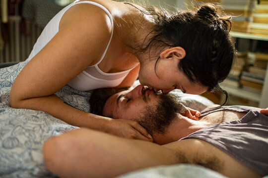 Young couple kissing in bed at home
