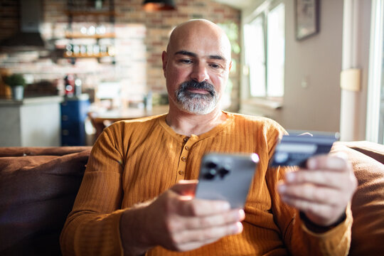 Middle-aged man shopping online at home