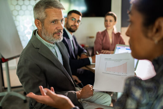 Business team discussing growth report in office meeting