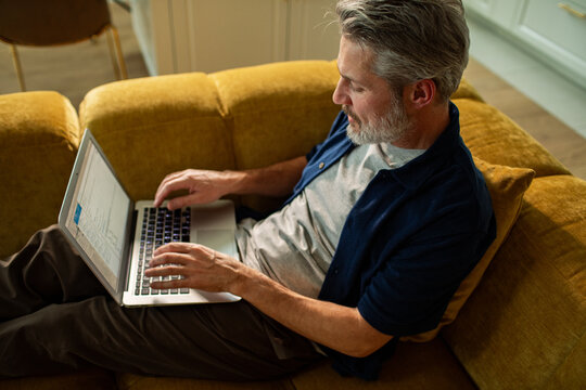 Middle aged man working on laptop at home