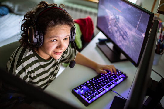 Teen gamer playing pc game at home