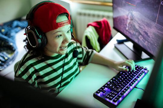 Teen gamer streaming at home computer desk