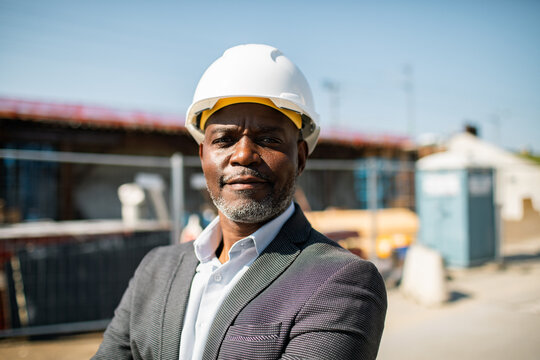 Confident construction manager in hard hat at job site