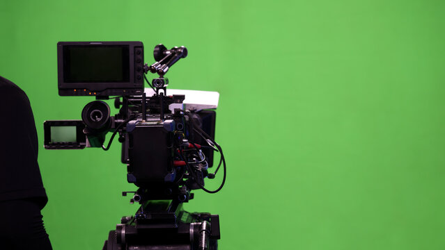 Behind the scenes. BTS of TV commercial movie film or video shooting production which pro camera crew setting up on green screen for chroma key technique in studio. Greenscreen background shooting set