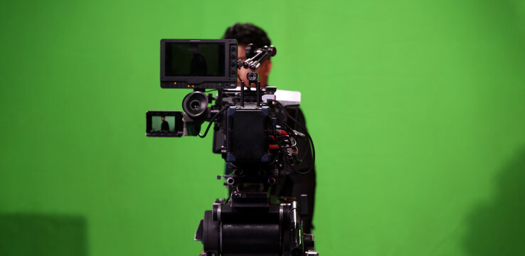 Behind the scenes. BTS of TV commercial movie film or video shooting production which pro camera crew setting up on green screen for chroma key technique in studio. Greenscreen background shooting set