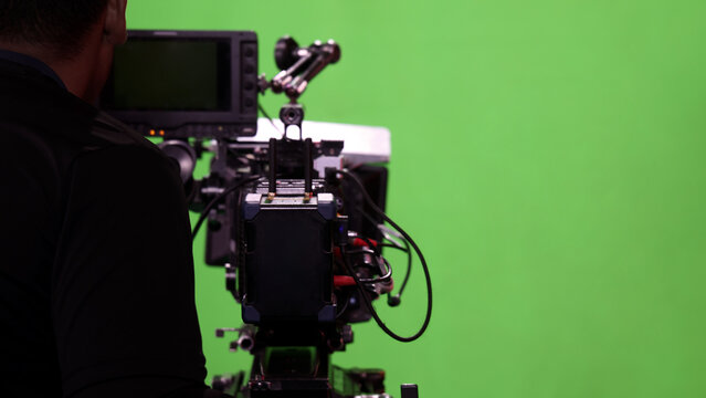Behind the scenes. BTS of TV commercial movie film or video shooting production which pro camera crew setting up on green screen for chroma key technique in studio. Greenscreen background shooting set