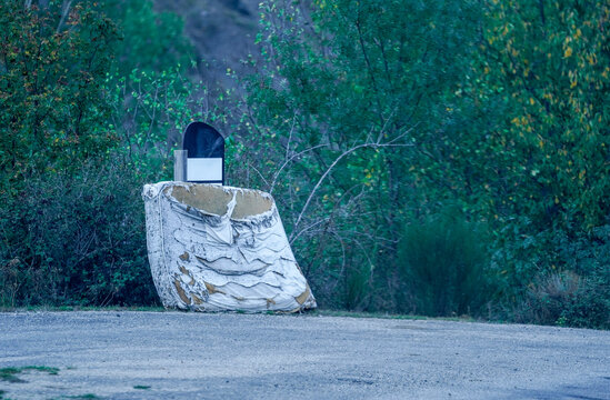 Old mattress discarded by road in forest showing waste and degradation