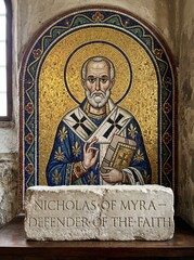 Fototapeta premium Mosaic icon of saint Nicholas of Myra holding gospel book with golden halo in byzantine church. Christian orthodoxy and religious heritage concept. Historical faith and Christmas tradition