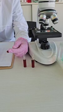 Laboratory setup showing microscope, colorful liquids in test tubes and bottles during a scientific experiment