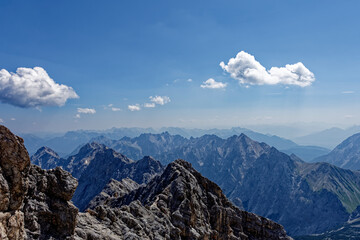 Obraz premium Layered Alpine Mountain Ranges and Paraglider Viewed from Zugspitze Summit