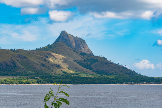 Exotic landscape of Mules Island featuring dramatic savanna hills, pristine white sand beaches and tropical coastal scenery in South Flores, Indonesia
