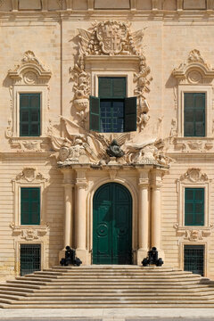 Ornate limestone building facade with columned entrance, Malta