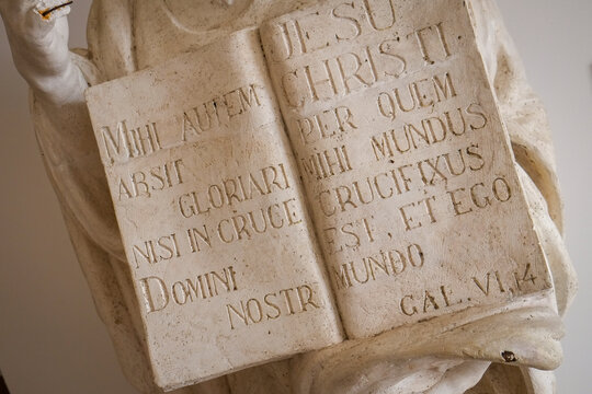 Carved marble book with Latin inscription on a religious statue 