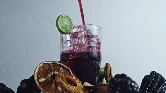Pouring Peruvian Chicha Morada Purple Corn Drink with Lime and Cinnamon