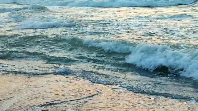 Waves with white foam on sea on backdrop of sunset and dawn. Storm. Stormy sea. Coast sand seashore. Seaside shore coastline. Natural background. Nature backdrop storm