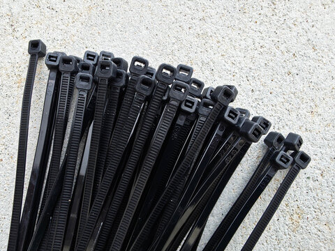 Black plastic cable ties for electrical wire management and industrial organization