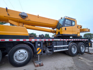 Yellow mobile crane truck parked at a construction site for heavy lifting operations. © Muhammad Umar