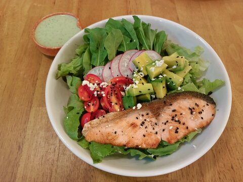 Grilled salmon salad bowl with fresh vegetables, top view