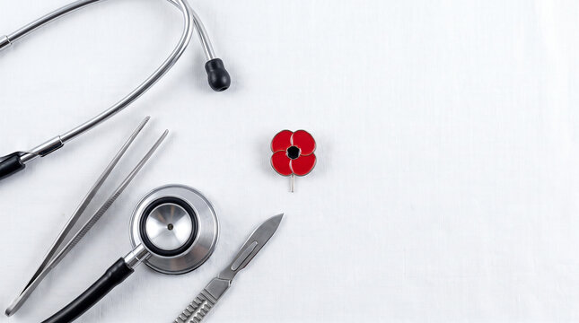 Medical tools and poppy pin on white fabric for healthcare services.