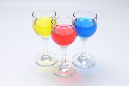 Colorful drinks in glasses on light grey background, closeup