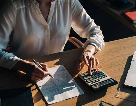 Female accountant calculating a business budget at a modern office desk. Finance concept focused on accounting, expenses, financial planning, budgeting, reports, money management, business analysis.