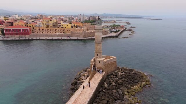  View of Chania with the amazing lighthouse, mosque, venetian shipyards, Crete, Greece.Waves crashing on lighthouse, Beautiful Greece and best scenic places - panorama
