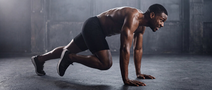 Mountain climbers exercise performed by athletic man in dark industrial gym, showing intense cardio training, core workout strength, sweaty muscular body, and fitness motivation