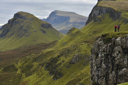Hikers in volcanic landscape, Leum na Luirginn, Flodigarry, Scottish Highlands, Isle of Skye, Scotland, United Kingdom