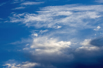 Fototapeta premium Beautiful morning clouds of an approaching atmospheric front, illuminated by sun rays, signalling changing weather from sunny to rainy conditions.