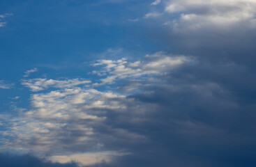 Fototapeta premium Beautiful morning clouds of an approaching atmospheric front, illuminated by sun rays, signalling changing weather from sunny to rainy conditions.