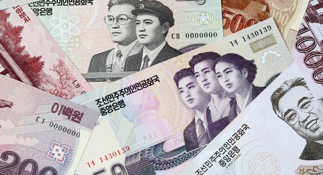 North Korean won money bills in pile on table. North Korea KPW currency cash close up