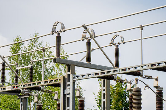 High-voltage electrical substation switchyard featuring porcelain post insulators busbar loop connectors and galvanized steel gantry structures