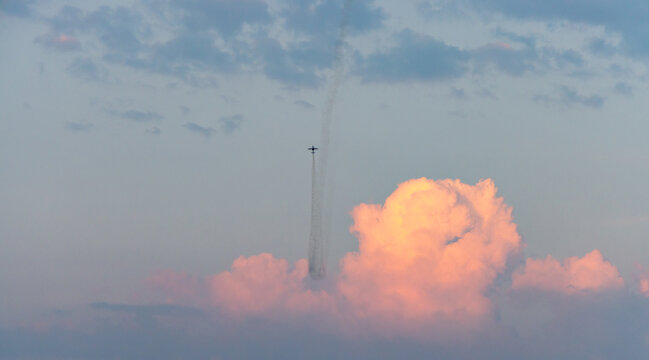 Aerobatic Plane Performing Vertical Smoke Maneuver Over Pink Clouds at Air Show in Chilliwack, BC, Canada
