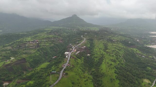 Expansive aerial drone view of scenic Pawna Lake reservoir surrounded by lush green hills under overcast monsoon sky⁠