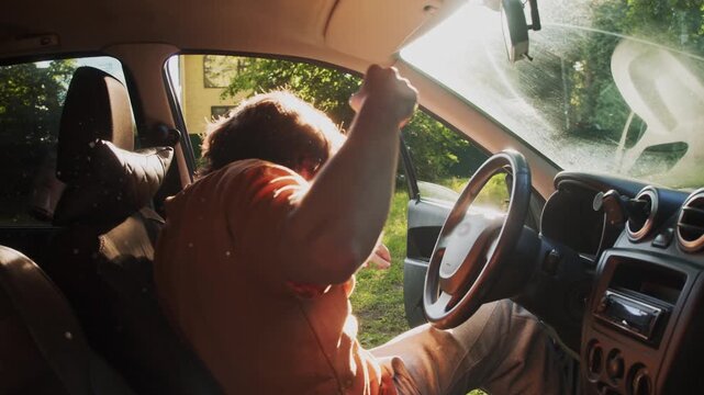 Intoxicated man sits behind the steering wheel after a summer party, illustrating the danger and illegality of drunk driving.