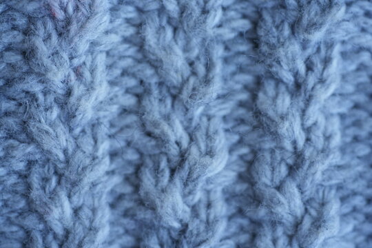 Gray cable knit fabric texture background soft gray knitted fabric with a classic cable knit pattern. Cozy textured yarn with braided stitches creates a warm background ideal for sweaters, winter fash