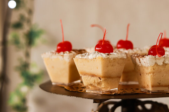 Mini Cream Desserts Topped with Red Cherries