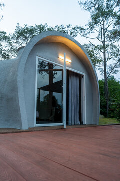 Modern curved concrete building surrounded by trees