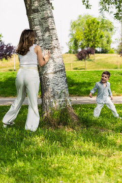 Mother and son playing hide and seek in park