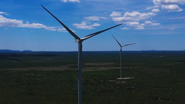 Aerial Drone View of Wind Turbines in a Green Landscape with Mountains