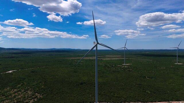 Aerial Drone View of Wind Turbines in a Green Landscape with Mountains