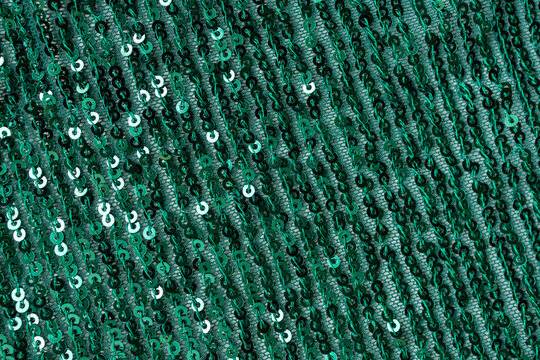 Emerald green sequin fabric texture shimmering background