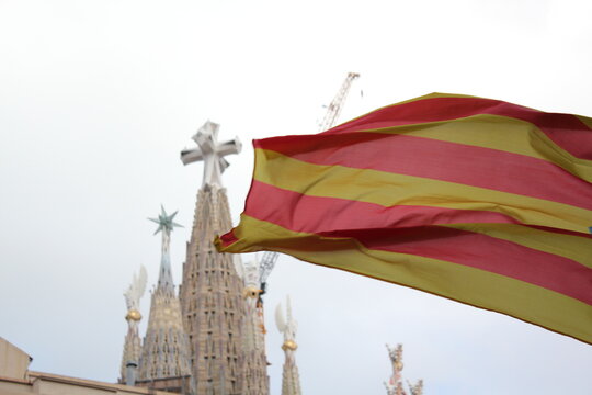 A Catalan flag waving with La Sagrada Familia on the background.