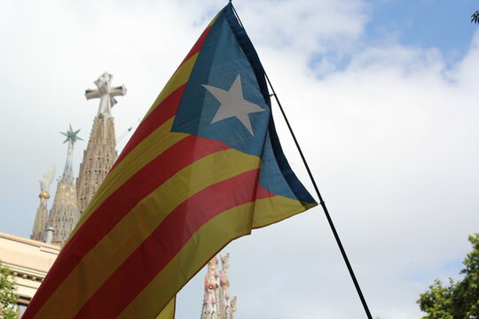 A Catalan flag waving with La Sagrada Familia on the background.