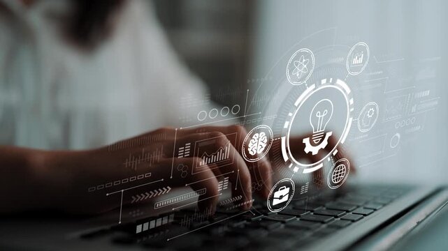 Hands typing on a laptop with glowing technology icons and data analysis graphics projected on the screen in a light-filled modern workspace environment. Entropy.