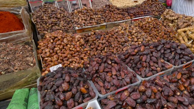 Marrakech, morocco. August 8, 2026. Colorful stall in a traditional moroccan souk displaying various types of dried dates, figs, and aromatic spices for sale at a local bazaar