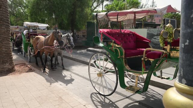 Marrakech, morocco. August 8, 2026. Colorful horse drawn carriages waiting for tourists on a sunny day in marrakech. Traditional moroccan transportation offering tours of the city