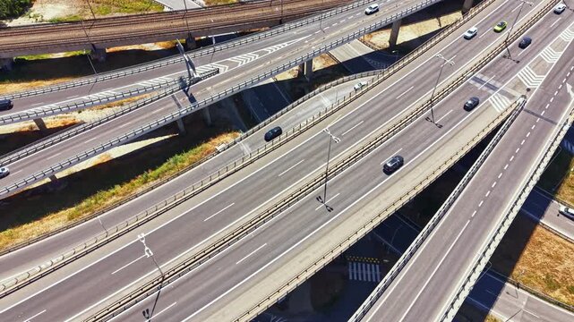 Vehicles travel on different levels of a highway system. The scene shows busy roads with lanes merging and diverging. It is daytime with clear visibility.