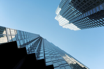 Fototapeta premium Modern glass skyscrapers in downtown financial district viewed from below