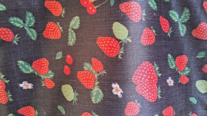 Vibrant red strawberry pattern printed on dark smooth textile fabric material © Sueliton